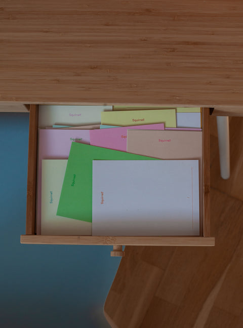 Open wooden drawer filled with memo sheets in various colors labeled "Squirrel!"