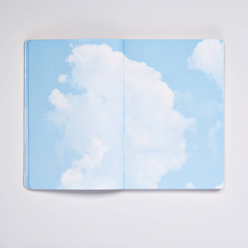 Open Clouds Junk Journal spread showing bright blue sky with fluffy white cumulus clouds