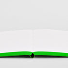 Open neon green bullet journal by Nuuna with colored edges, laying completely flat on a grey background