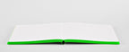 Open neon green bullet journal by Nuuna with colored edges, laying completely flat on a grey background