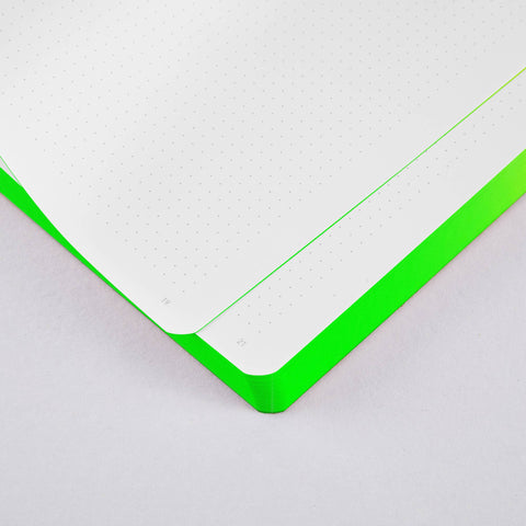 Close-up of neon green recycled leather bullet journal showing the dotted and numbered inner pages and vibrant green colored edges