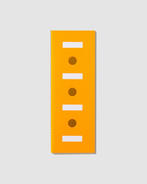 Orange notebook with white rectangles and gold foiled circles on the cover, on a light gray background