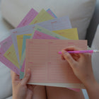 Person holding colorful weekly planner memo sheets by Fluo and a pink mechanical pencil by Mark's Inc