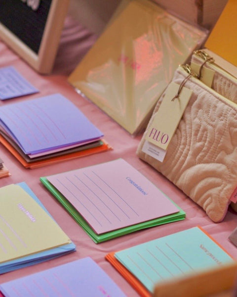 Stacks of foiled notecards and envelopes on a table, in assorted colors