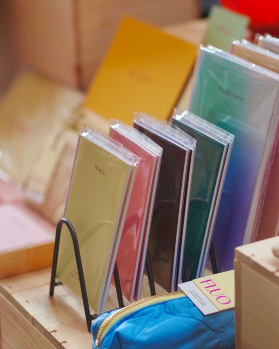 Stacks of colorful notebooks neatly displayed at a market stand table