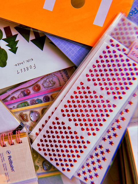 Collection of stationery items including notebooks, postcards, and stickers.